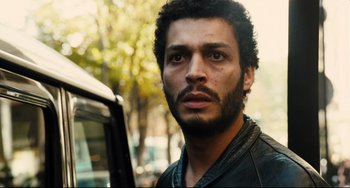 Movie still from “A Prophet” (2009), directed by Jacques Audiard – A person wearing a leather jacket; Close Up shot, Over the shoulder angle