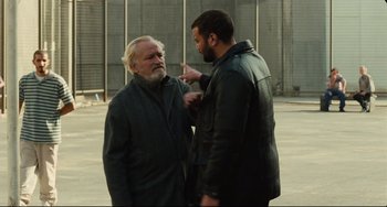 Movie still from “A Prophet” (2009), directed by Jacques Audiard – Two men standing next to each other on the street; Medium shot, Over the shoulder angle