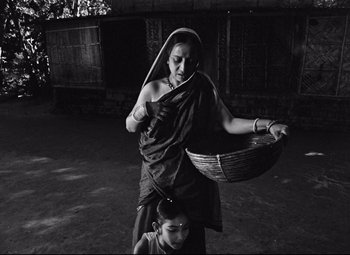 An old woman carrying a basket on her head