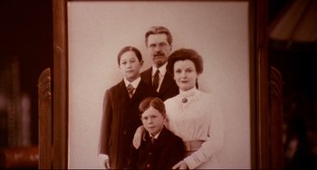 Movie still from “A River Runs Through It” (1992), directed by Robert Redford – An old photo of a man , woman , and two children; Medium shot, High angle