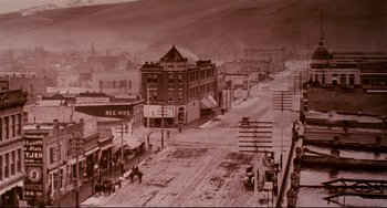 Movie still from “A River Runs Through It” (1992), directed by Robert Redford – An old photo of a street with a horse drawn carriage in the foreground; Extreme Wide shot, High angle