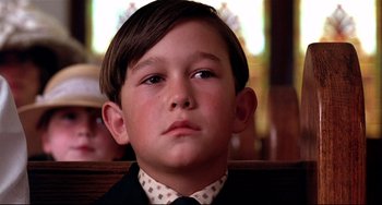 Movie still from “A River Runs Through It” (1992), directed by Robert Redford – A young boy wearing a suit and a tie; Close Up shot, Low angle