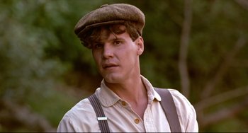 Movie still from “A River Runs Through It” (1992), directed by Robert Redford – A young man wearing a hat and suspenders; Close Up shot, Low angle