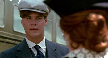 Movie still from “A River Runs Through It” (1992), directed by Robert Redford – A man in a suit and hat looking at a woman in a hat; Close Up shot, Over the shoulder angle