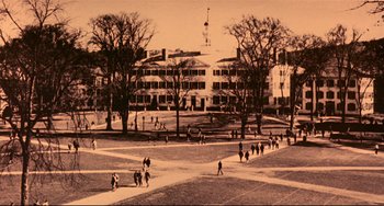 Movie still from “A River Runs Through It” (1992), directed by Robert Redford – A group of people walking on a path in front of a building; Extreme Wide shot, High angle