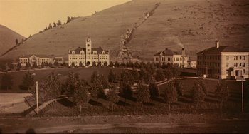 Movie still from “A River Runs Through It” (1992), directed by Robert Redford – An old photo of a building on top of a hill; Extreme Wide shot, High angle