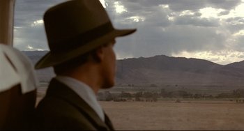 Movie still from “A River Runs Through It” (1992), directed by Robert Redford – A man wearing a hat looking out over a field; Extreme Wide shot, Over the shoulder angle