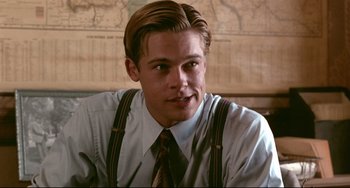 Movie still from “A River Runs Through It” (1992), directed by Robert Redford – A young man with long blonde hair wearing a dress shirt and suspenders; Close Up shot, Over the shoulder angle