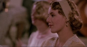 Movie still from “A River Runs Through It” (1992), directed by Robert Redford – A woman in a white dress is looking to her left; Close Up shot, Over the shoulder angle