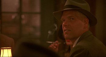 Movie still from “A River Runs Through It” (1992), directed by Robert Redford – A man in a hat is smoking a cigarette; Close Up shot, Over the shoulder angle
