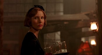 Movie still from “A River Runs Through It” (1992), directed by Robert Redford – A woman holding a tray with two glasses of wine; Close Up shot, Low angle