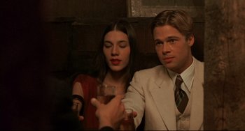 Movie still from “A River Runs Through It” (1992), directed by Robert Redford – A man and a woman sitting next to each other holding drinks; Medium shot, Over the shoulder angle