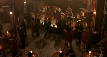 Movie still from “A River Runs Through It” (1992), directed by Robert Redford – A group of people standing in a room with candles; Extreme Wide shot, High angle