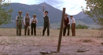 Movie still from “A River Runs Through It” (1992), directed by Robert Redford – A group of men standing in a field with hats on; Wide shot, Low angle