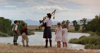 Movie still from “A River Runs Through It” (1992), directed by Robert Redford – A group of people standing next to a body of water; Wide shot, Low angle