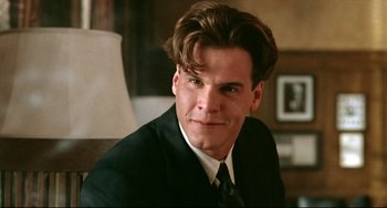Movie still from “A River Runs Through It” (1992), directed by Robert Redford – A person wearing a suit and tie; Close Up shot, Over the shoulder angle