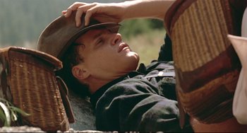 Movie still from “A River Runs Through It” (1992), directed by Robert Redford – A man laying on the ground with his head tilted down; Close Up shot, High angle