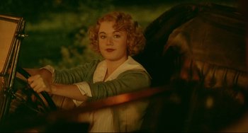Movie still from “A River Runs Through It” (1992), directed by Robert Redford – A woman with red curly hair leaning on a fence; Medium shot, High angle