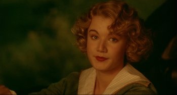 Movie still from “A River Runs Through It” (1992), directed by Robert Redford – A young woman with blonde curly hair wearing a striped shirt; Close Up shot, High angle