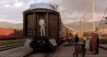 Movie still from “A River Runs Through It” (1992), directed by Robert Redford – A man standing on the side of a train car; Wide shot, Low angle