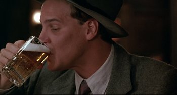 Movie still from “A River Runs Through It” (1992), directed by Robert Redford – A man wearing a hat and eating a piece of food; Close Up shot, Low angle