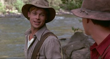 Movie still from “A River Runs Through It” (1992), directed by Robert Redford – A man wearing a hat standing next to another man; Medium shot, Over the shoulder angle