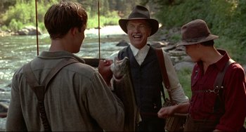Movie still from “A River Runs Through It” (1992), directed by Robert Redford – A group of men standing next to each other near a river; Medium shot, Over the shoulder angle