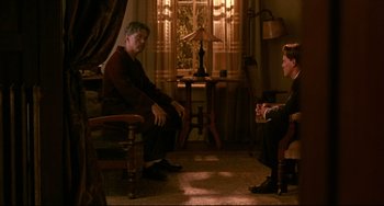 Movie still from “A River Runs Through It” (1992), directed by Robert Redford – Two people sitting in a living room talking to each other; Wide shot, High angle