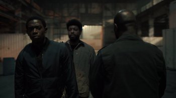 Movie still from “Snowfall” (2017), directed by Hiro Murai – A group of men standing next to each other in a building; Medium shot, Over the shoulder angle