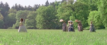 Movie still from “A Royal Affair” (2012), directed by Nikolaj Arcel – Two women in a grassy field holding umbrellas; Extreme Wide shot, High angle