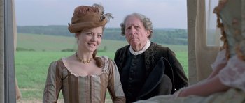 Movie still from “A Royal Affair” (2012), directed by Nikolaj Arcel – A woman and an old man standing next to each other; Medium shot, Over the shoulder angle