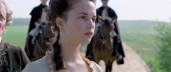 Movie still from “A Royal Affair” (2012), directed by Nikolaj Arcel – A young woman in a dress standing in front of a horse; Close Up shot, Over the shoulder angle