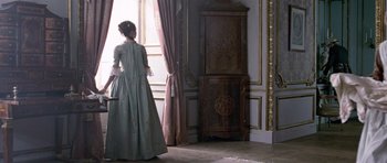 Movie still from “A Royal Affair” (2012), directed by Nikolaj Arcel – A woman dressed in period clothing looking out a window; Wide shot, Low angle