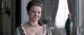 Movie still from “A Royal Affair” (2012), directed by Nikolaj Arcel – A woman in a dress with a flower in her hair; Close Up shot, Over the shoulder angle