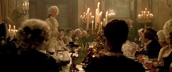 Movie still from “A Royal Affair” (2012), directed by Nikolaj Arcel – A group of people sitting around a table with candles; Medium shot, Low angle