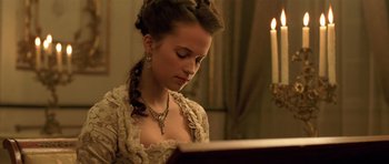Movie still from “A Royal Affair” (2012), directed by Nikolaj Arcel – A young woman in a victorian dress looking down at a piano; Close Up shot, Low angle