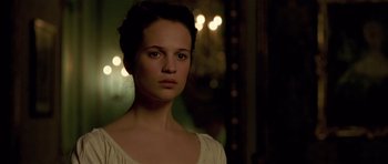 Movie still from “A Royal Affair” (2012), directed by Nikolaj Arcel – A woman in a white shirt is looking at the camera; Close Up shot, Over the shoulder angle