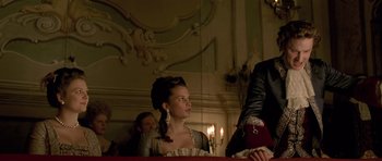 Movie still from “A Royal Affair” (2012), directed by Nikolaj Arcel – A young woman in a period dress looking at something; Medium shot, Low angle