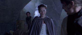 Movie still from “A Royal Affair” (2012), directed by Nikolaj Arcel – A woman in a white dress and a purple cape; Medium shot, Over the shoulder angle