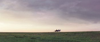 Movie still from “A Royal Affair” (2012), directed by Nikolaj Arcel – Two people on horseback riding across a field; Extreme Wide shot, Low angle