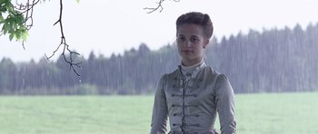 Movie still from “A Royal Affair” (2012), directed by Nikolaj Arcel – A woman in a white dress standing in the rain; Medium shot, Low angle