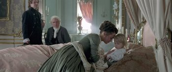Movie still from “A Royal Affair” (2012), directed by Nikolaj Arcel – A woman and a baby in a room with a man; Medium shot, Over the shoulder angle
