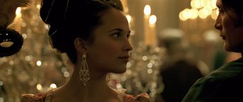 Movie still from “A Royal Affair” (2012), directed by Nikolaj Arcel – A woman wearing a dress and a pair of dangling earrings; Close Up shot, Over the shoulder angle