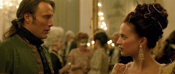 Movie still from “A Royal Affair” (2012), directed by Nikolaj Arcel – A man and a woman talking to each other in front of a group of people; Close Up shot, Over the shoulder angle