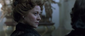 Movie still from “A Royal Affair” (2012), directed by Nikolaj Arcel – An older woman in a black dress looking to her left; Close Up shot, Low angle