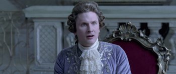 Movie still from “A Royal Affair” (2012), directed by Nikolaj Arcel – A man in a victorian era outfit looking at the camera; Close Up shot, Over the shoulder angle