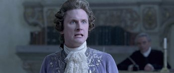 Movie still from “A Royal Affair” (2012), directed by Nikolaj Arcel – A man in a purple jacket and white lace shirt; Close Up shot, Over the shoulder angle