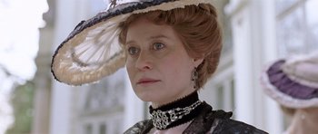 Movie still from “A Royal Affair” (2012), directed by Nikolaj Arcel – A person wearing a dress and a hat; Close Up shot, Low angle
