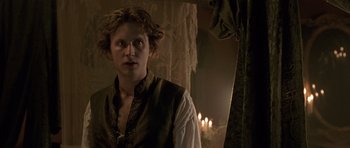 Movie still from “A Royal Affair” (2012), directed by Nikolaj Arcel – A man in a medieval garb standing next to a window; Close Up shot, Over the shoulder angle