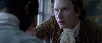 Movie still from “A Royal Affair” (2012), directed by Nikolaj Arcel – A man in a brown and white dress looking at a woman; Close Up shot, Over the shoulder angle